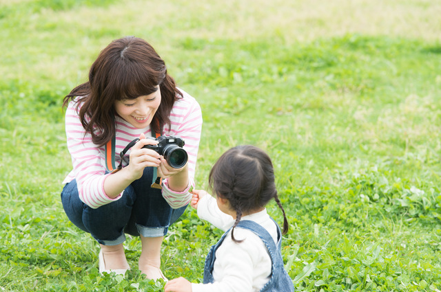 公園で子供の写真を撮るお母さん